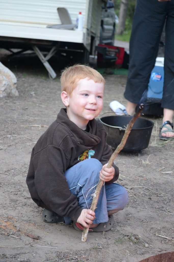 little boy roasting marshmallows on a stick