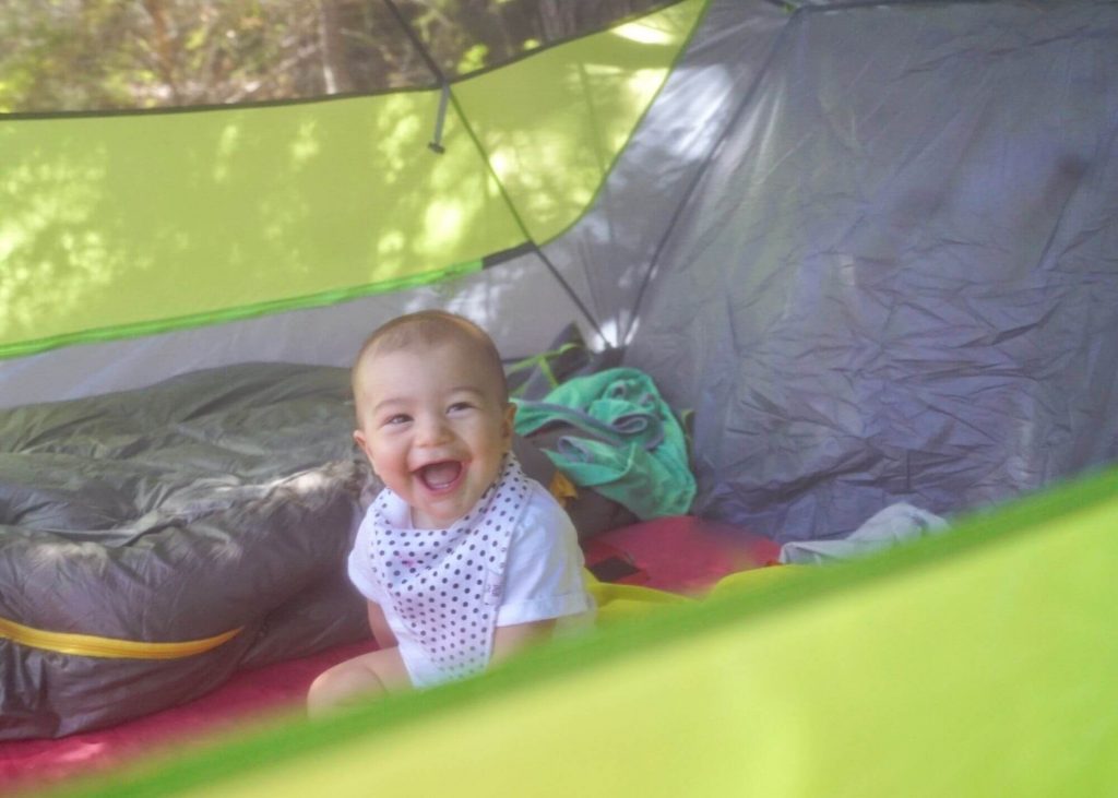 a smiling baby in a tent