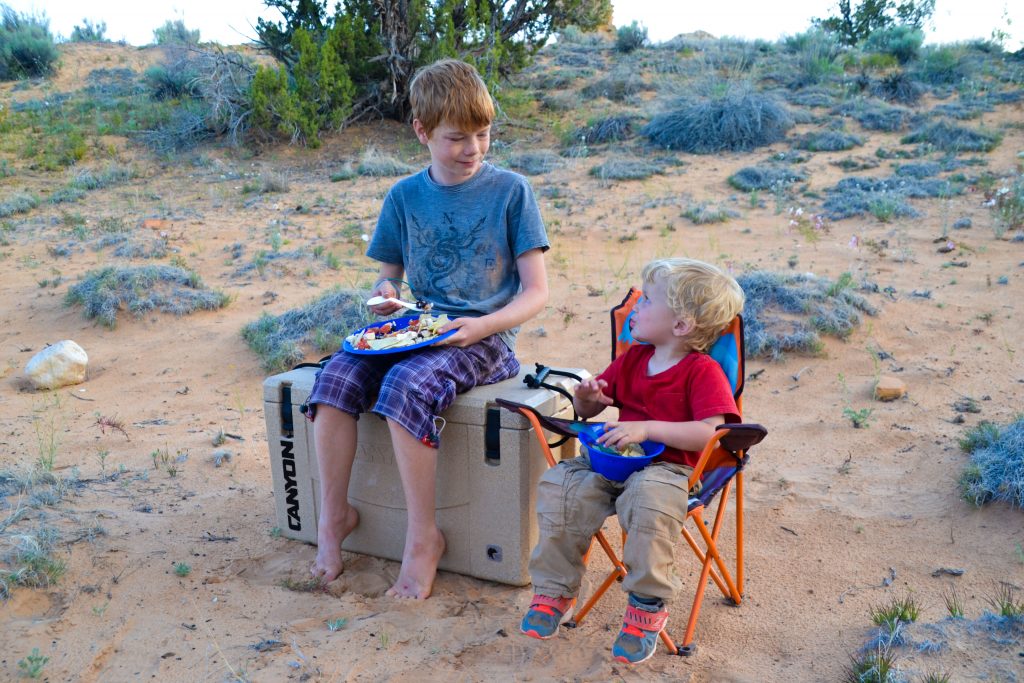 boys eating outside while camping