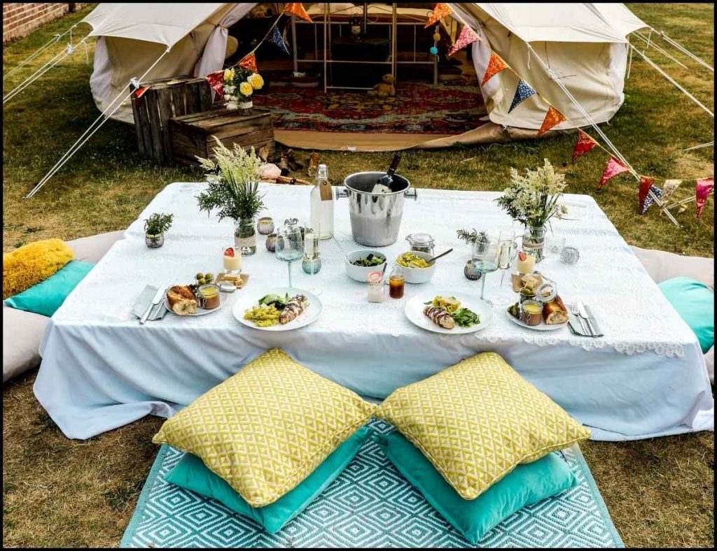 A glamping table draped with blue camping table cloth 